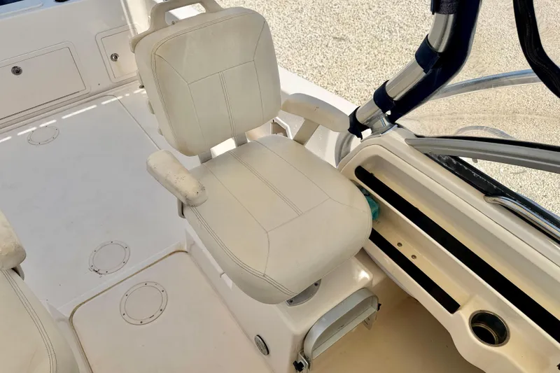 Slide: The Image of Captain's chair on 2016 Grady-White Journey 258 boat, featuring white upholstery and armrests. - 18