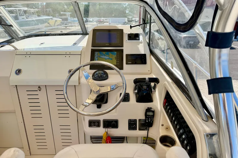 Slide: The Image of Helm of 2016 Grady-White Journey 258 boat with steering wheel and navigation equipment. - 9