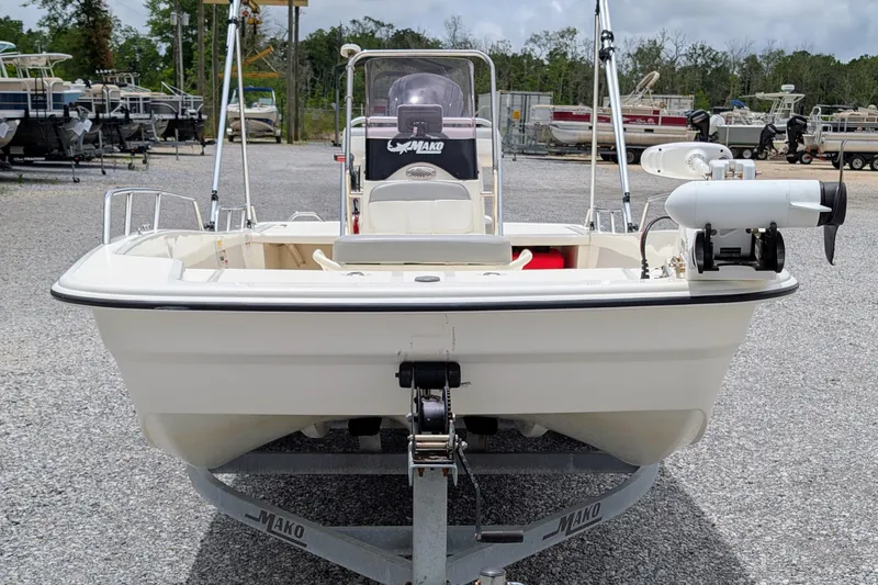 Slide: The Image of 2021 Mako Pro Skiff 17 CC boat on trailer, parked in a gravel lot. - 2