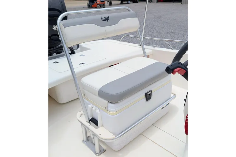 Slide: The Image of 2021 Mako Pro Skiff 17 CC boat seat with storage compartment, featuring gray and white upholstery. - 7