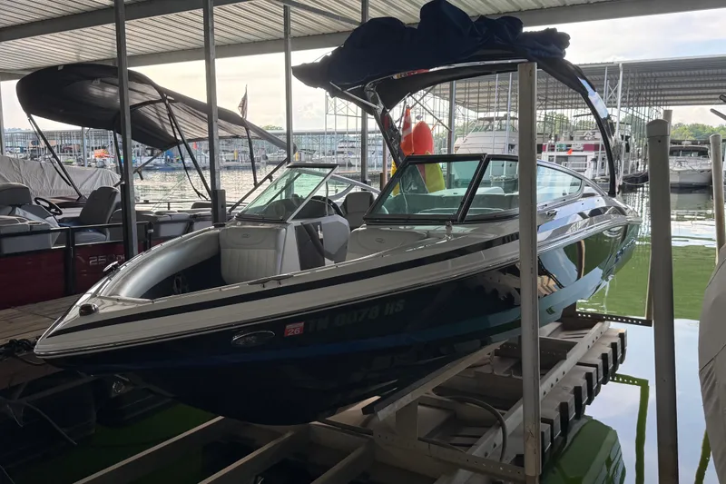 The Image of 2013 Regal 2100 Bowrider boat docked in a marina under a covered slip. - 0