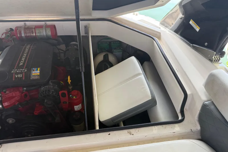 Slide: The Image of 2013 Regal 2100 Bowrider engine compartment with Volvo Penta 225 V6 engine and fire extinguisher. - 13