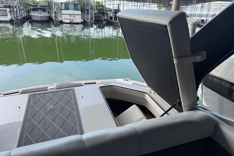 Slide: The Image of 2013 Regal 2100 Bowrider boat interior with open storage compartment at marina. - 20