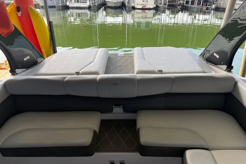 Slide: The Image of 2013 Regal 2100 Bowrider boat interior with cushioned seating and lake view. - 22