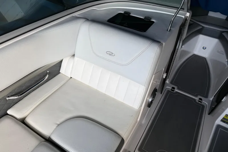 Slide: The Image of Interior seating of a 2013 Regal 2100 Bowrider boat, featuring white upholstery. - 25