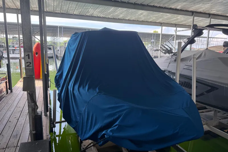 Slide: The Image of Covered 2013 Regal 2100 Bowrider boat docked in a marina. - 27