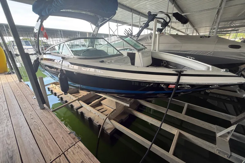 Slide: The Image of 2013 Regal 2100 Bowrider boat docked in a covered marina. - 4