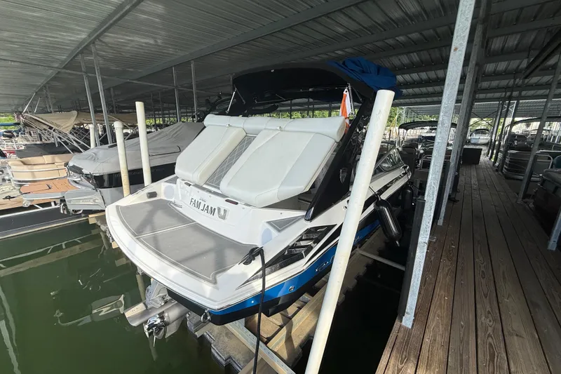 Slide: The Image of 2013 Regal 2100 Bowrider docked in a covered marina slip. - 5