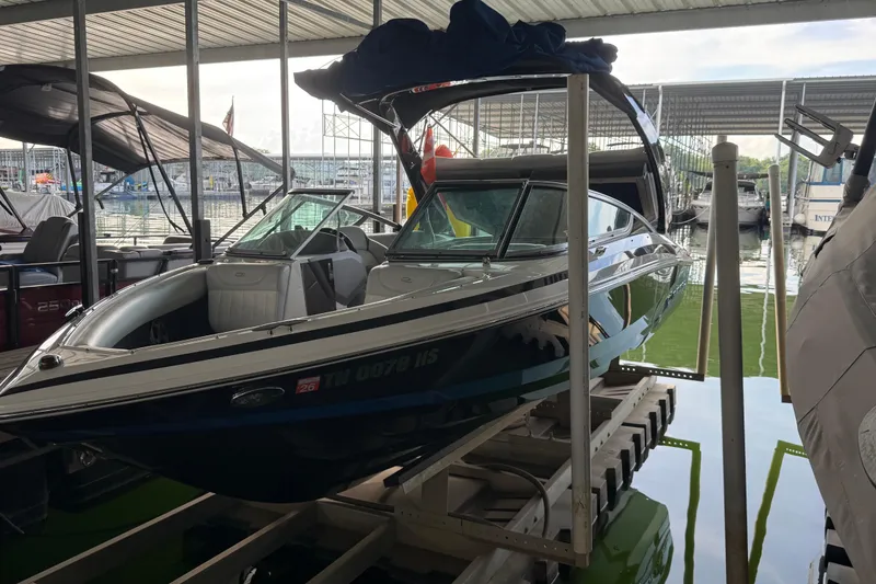 Slide: The Image of 2013 Regal 2100 Bowrider boat docked in a covered marina. - 6