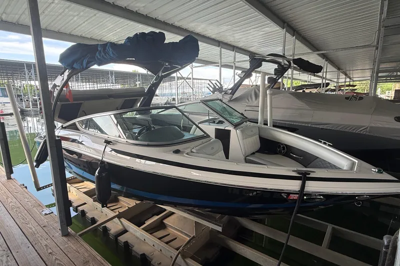 Slide: The Image of 2013 Regal 2100 Bowrider boat docked in a covered marina. - 7