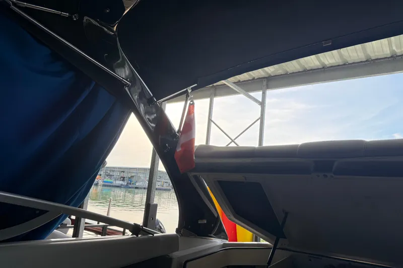 Slide: The Image of Interior view of a 2013 Regal 2100 Bowrider boat docked at a marina. - 9