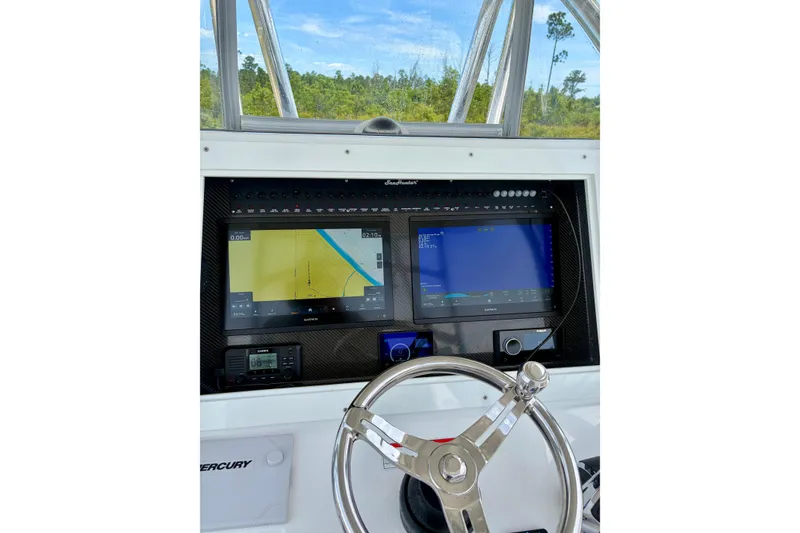 Slide: The Image of 2024 SeaHunter 31 Tournament boat dashboard with navigation screens and steering wheel. - 13
