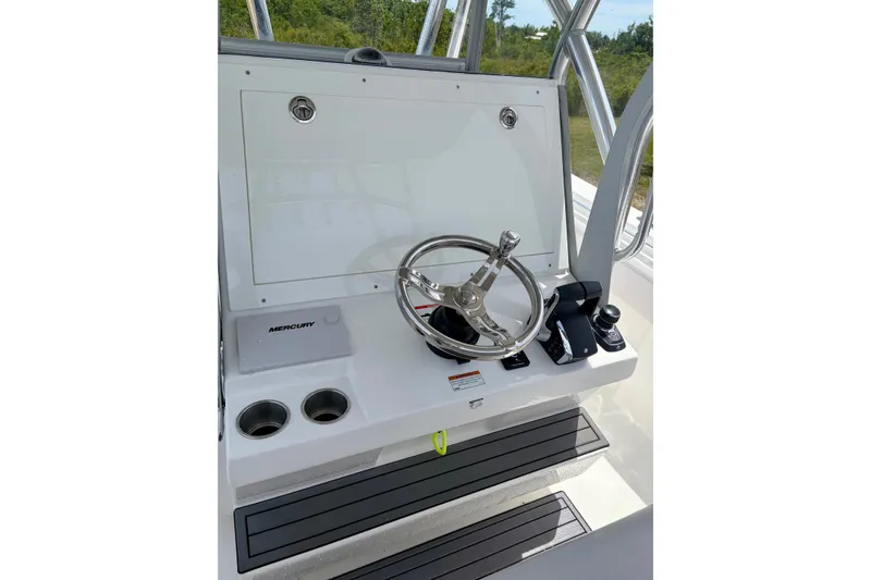 Slide: The Image of 2024 SeaHunter 31 Tournament helm with steering wheel and Mercury controls. - 16