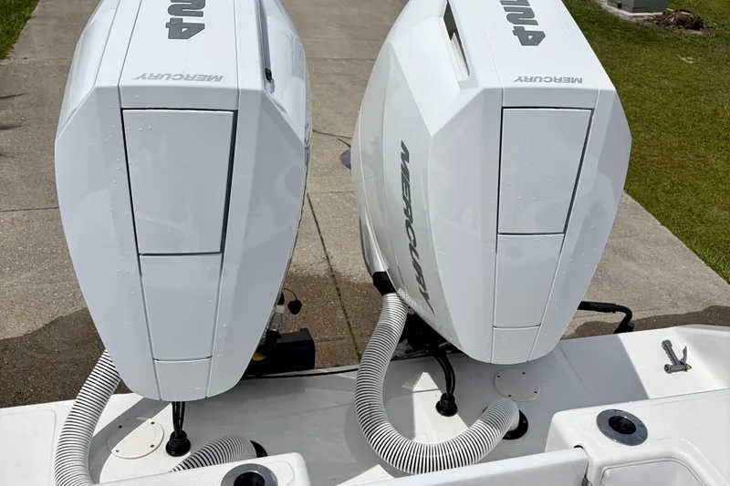 Slide: The Image of Twin Mercury outboard engines on a 2024 SeaHunter 31 Tournament boat, docked on concrete. - 29