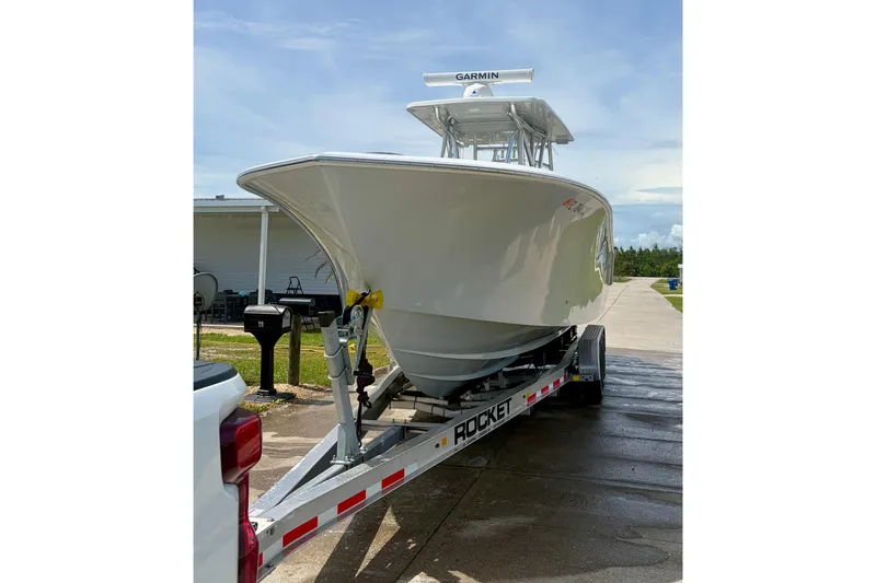 Slide: The Image of 2024 SeaHunter 31 Tournament boat on trailer, featuring Garmin equipment, parked outdoors. - 5