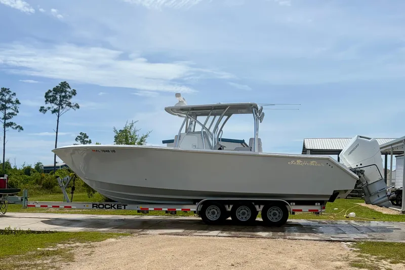 Slide: The Image of 2024 SeaHunter 31 Tournament boat on trailer, parked outdoors under clear sky. - 8