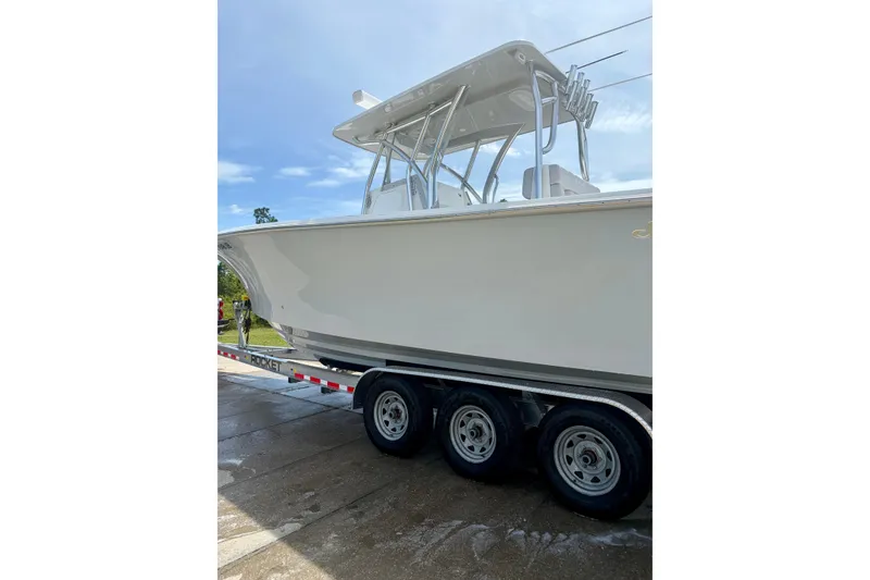 Slide: The Image of 2024 SeaHunter 31 Tournament boat on trailer, side view under clear sky. - 9