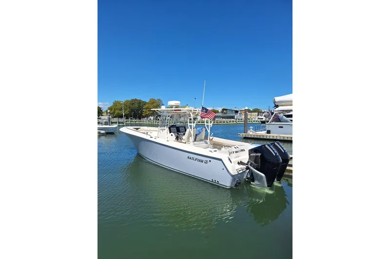 The Image of 2022 Sailfish 320 CC boat docked in a marina under clear blue skies. - 0