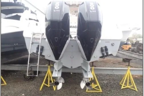 Slide: The Image of 2022 Sailfish 320 CC boat with dual outboard engines on stands. - 10