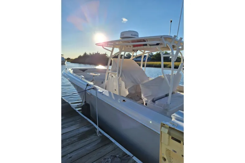 Slide: The Image of 2022 Sailfish 320 CC boat docked at sunset, featuring sleek design and modern equipment. - 3