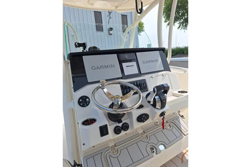 Slide: The Image of 2022 Sailfish 320 CC boat dashboard with Garmin navigation and Mercury controls. - 6