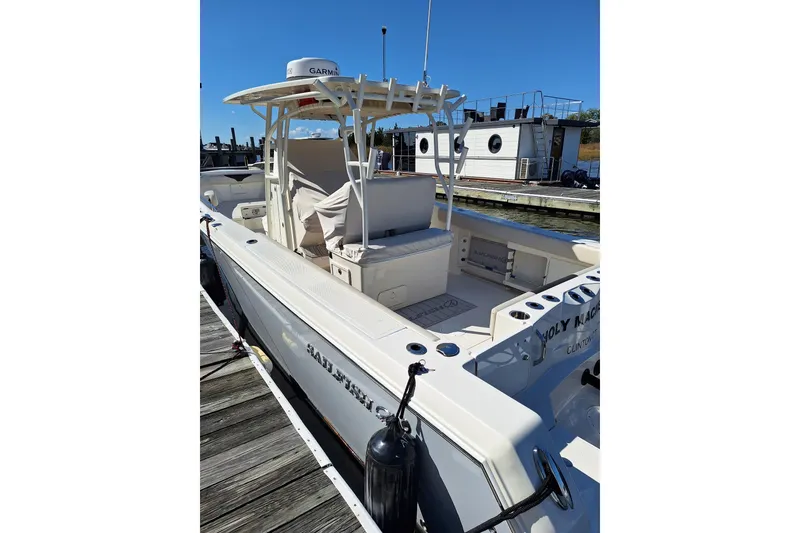 Slide: The Image of 2022 Sailfish 320 CC boat docked, featuring spacious deck and modern design. - 7