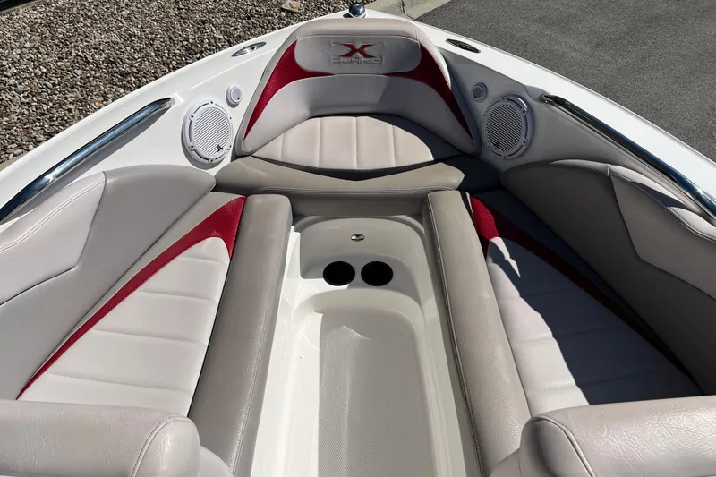 Slide: The Image of 2007 MasterCraft X-15 boat interior with red and gray seating, speakers, and cup holders. - 12