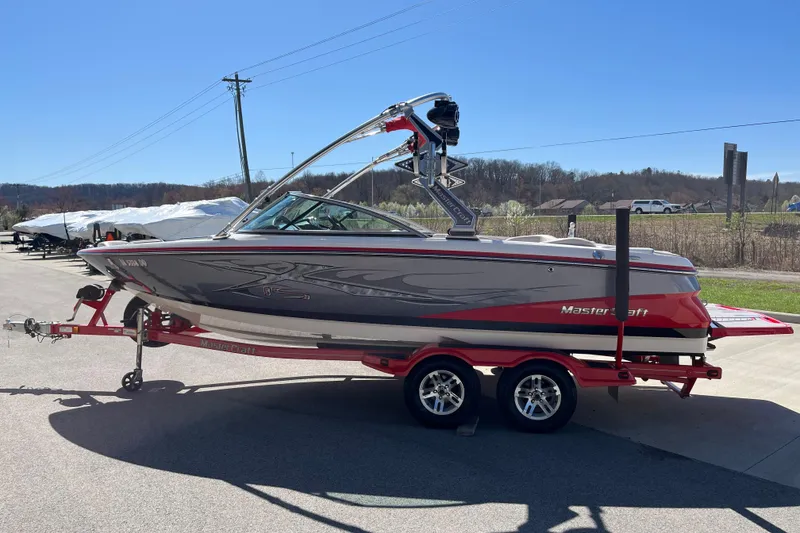 Slide: The Image of 2007 MasterCraft X-15 boat on trailer, parked outdoors under clear blue sky. - 5