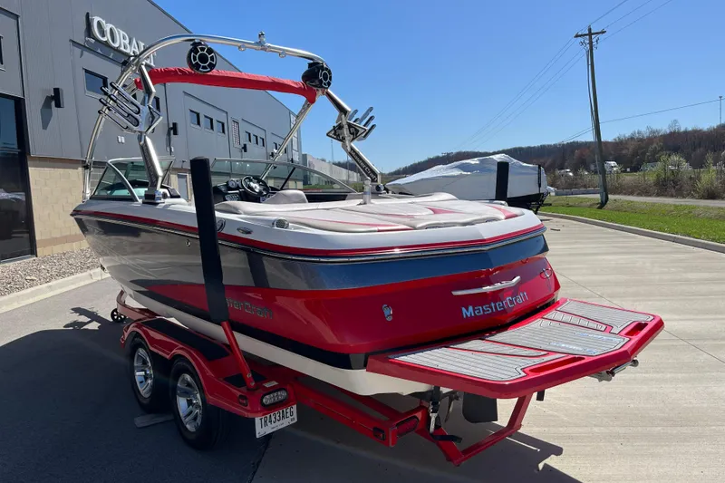Slide: The Image of 2007 MasterCraft X-15 boat in red, parked on a trailer outside a building. - 6