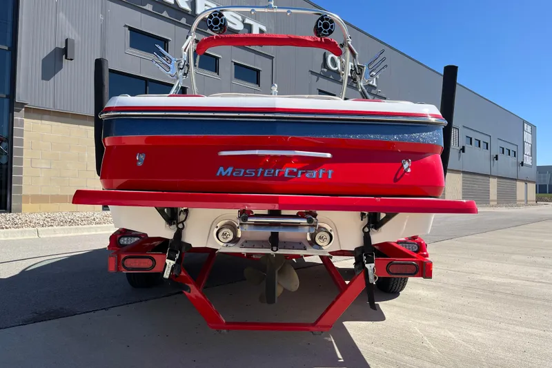 Slide: The Image of Red 2007 MasterCraft X-15 boat on trailer, parked outside a modern building. - 7