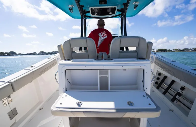Slide: The Image of 2019 Century 3200 Center Console boat interior with person steering on open water. - 14