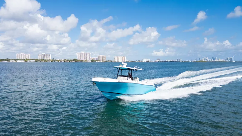 Slide: The Image of Century 3200 Center Console 2019 boat cruising on open water under a clear blue sky. - 2