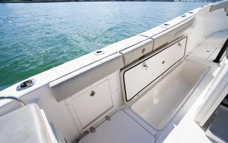 Slide: The Image of 2019 Century 3200 Center Console boat interior with storage compartments, on calm water. - 21