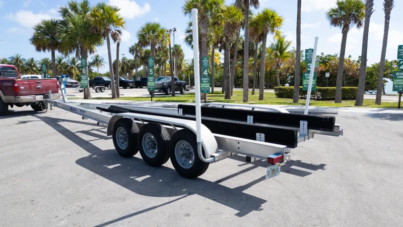 Slide: The Image of Triple-axle boat trailer parked near palm trees, suitable for 2019 Century 3200 Center Console. - 38