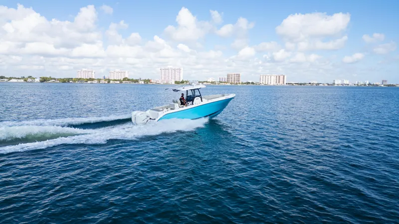 Slide: The Image of 2019 Century 3200 Center Console boat cruising on open water under a clear blue sky. - 44