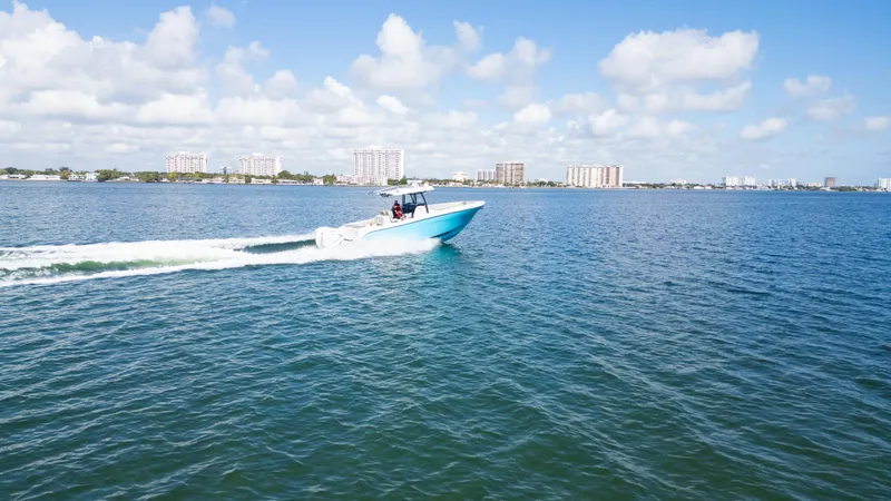 Slide: The Image of Century 3200 Center Console boat cruising on open water, 2019 model, under a clear blue sky. - 45