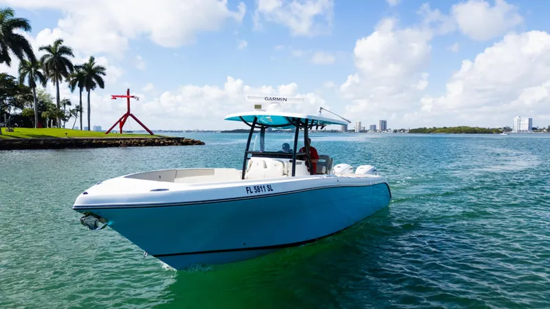 Slide: The Image of 2019 Century 3200 Center Console boat cruising on a sunny day near palm trees. - 46