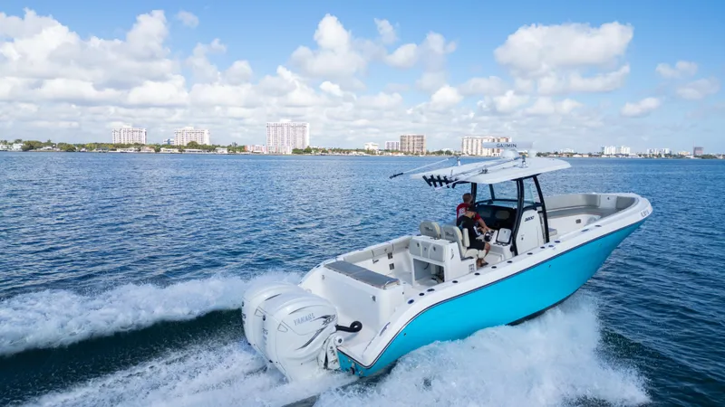 Slide: The Image of Century 3200 Center Console 2019 boat cruising on open water under a clear blue sky. - 5