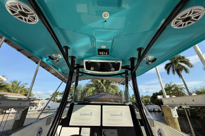 Slide: The Image of 2019 Century 3200 Center Console boat interior with Garmin electronics, docked near palm trees. - 53