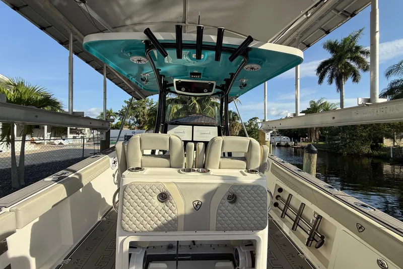 Slide: The Image of 2019 Century 3200 Center Console boat interior with seating and equipment, docked near palm trees. - 54