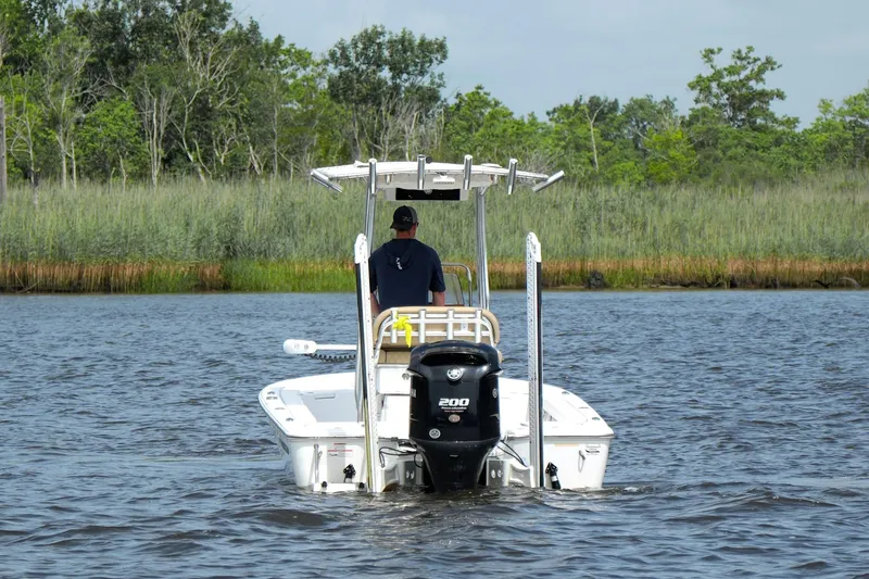 Slide: The Image of 2018 Sportsman Tournament 214 Bay Boat cruising on a calm river with lush greenery. - 4