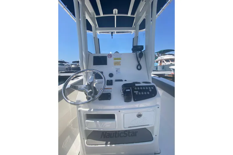 Slide: The Image of 2023 NauticStar 242L Offshore boat console with steering wheel and controls. - 13