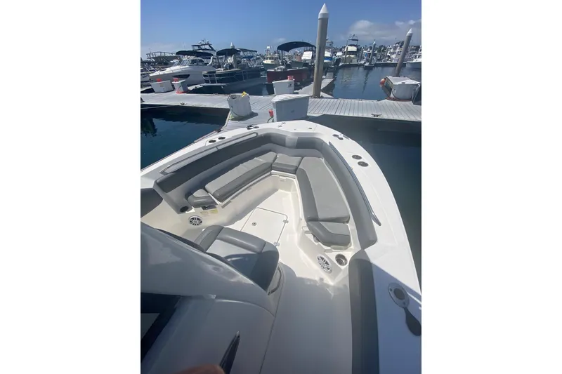 Slide: The Image of 2023 NauticStar 242L Offshore boat docked, featuring spacious seating and sleek design. - 14