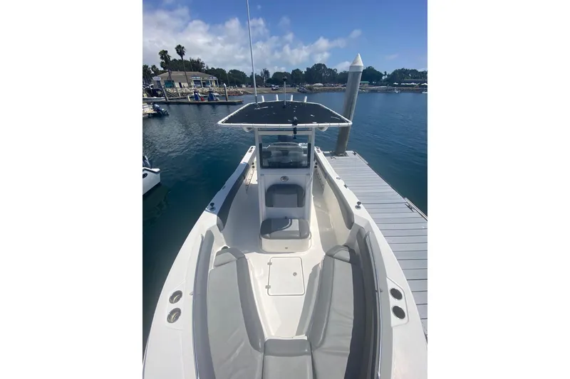 Slide: The Image of 2023 NauticStar 242L Offshore boat docked, featuring spacious seating and sleek design. - 15