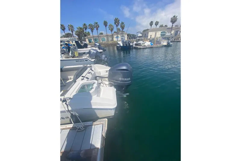 Slide: The Image of 2023 NauticStar 242L Offshore boat docked with Yamaha outboard motor in marina. - 18