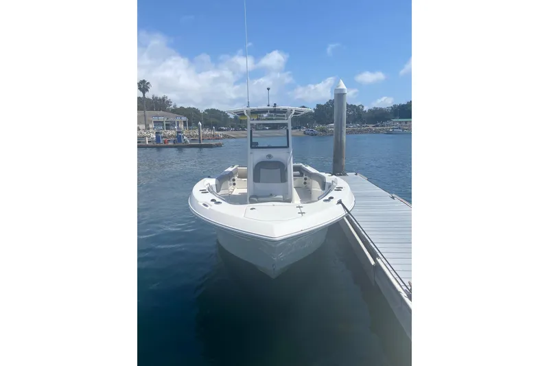 Slide: The Image of 2023 NauticStar 242L Offshore boat docked at marina under clear blue sky. - 8