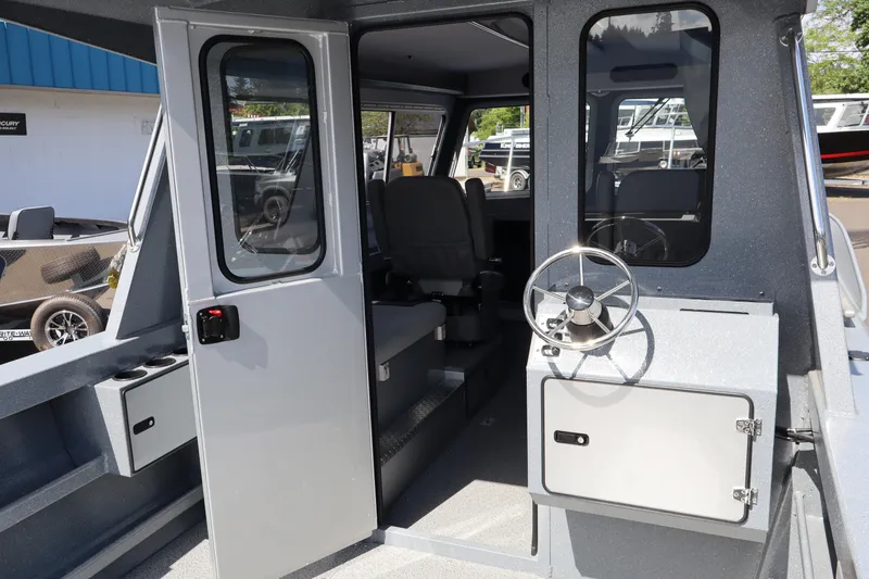 Slide: The Image of 2026 KingFisher 2825 Coastal Express boat interior with steering wheel and seating. - 21