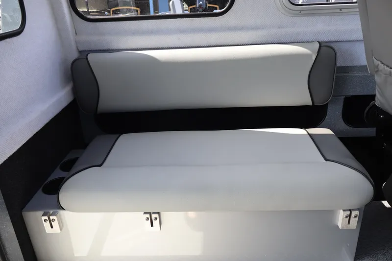 Slide: The Image of Interior seating of 2026 KingFisher 2825 Coastal Express boat, featuring cushioned bench and storage. - 23