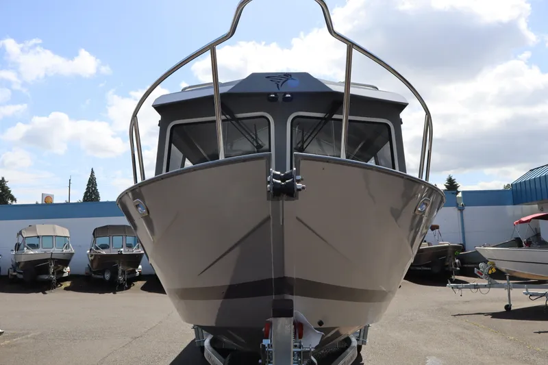 Slide: The Image of 2026 KingFisher 2825 Coastal Express boat, front view, parked outdoors under a cloudy sky. - 3