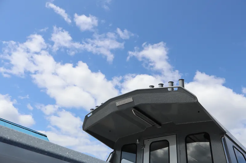 Slide: The Image of 2026 KingFisher 2825 Coastal Express boat against a bright blue sky with clouds. - 37